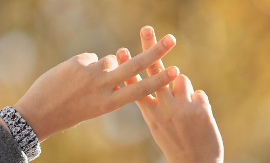 Two hands in the air, crossing two fingers on each hand over to create a hashtag sign.